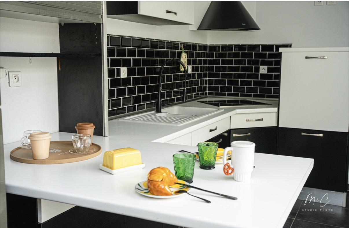 Espace repas avec table noire et chaises vertes